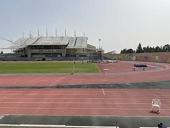 Außen-Leichtathletikstadion mit roter Laufbahn, grünem Spielfeld und moderner Tribüne für Trainingslager