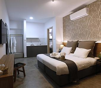Gemütliches Zimmer mit großem Bett, offener Kochnische und warmer Beleuchtung