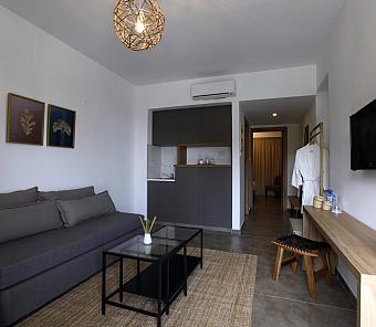 Wohnbereich mit grauem Sofa, Tisch und minimalistischem Design in neutralen Farben
