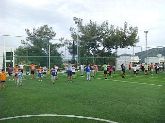Kinder und Athleten, die Gruppentraining auf einem Außensportplatz durchführen