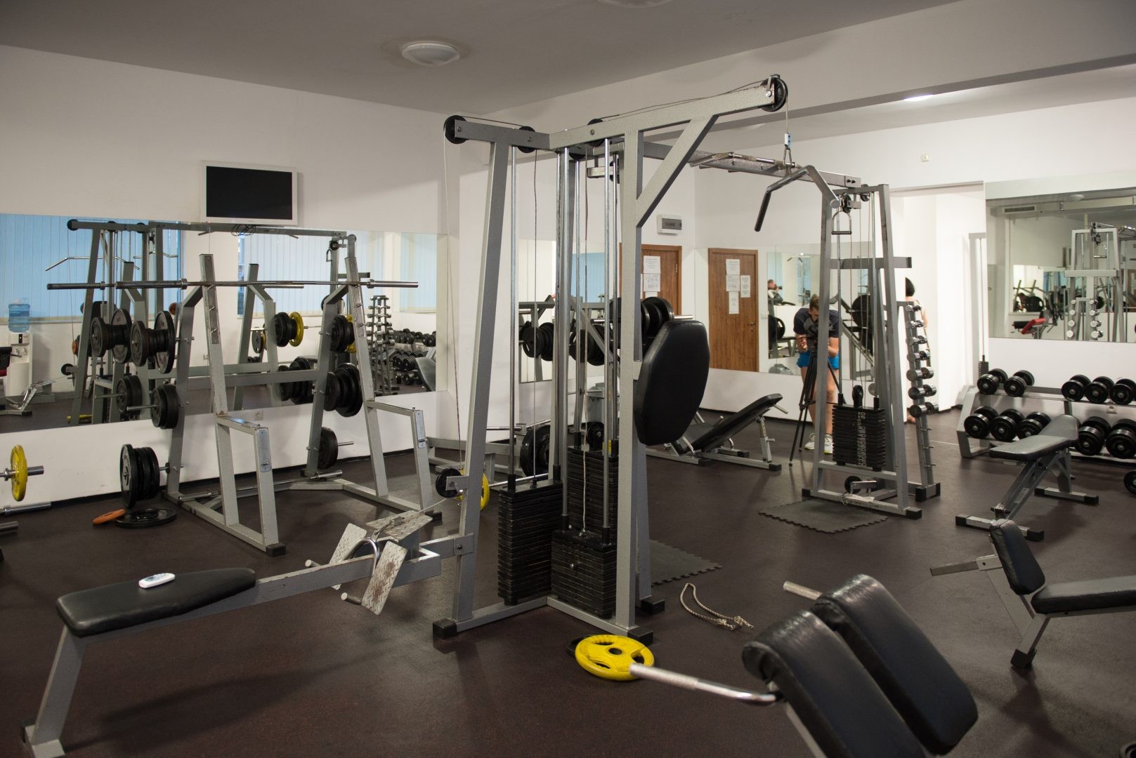 Gym with cable machines, benches, and free weights used for strength training camp workouts