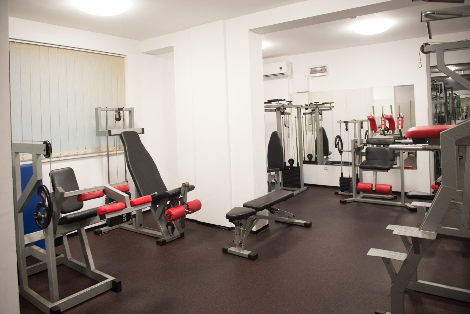 Compact gym room with benches and resistance machines for focused workout sessions