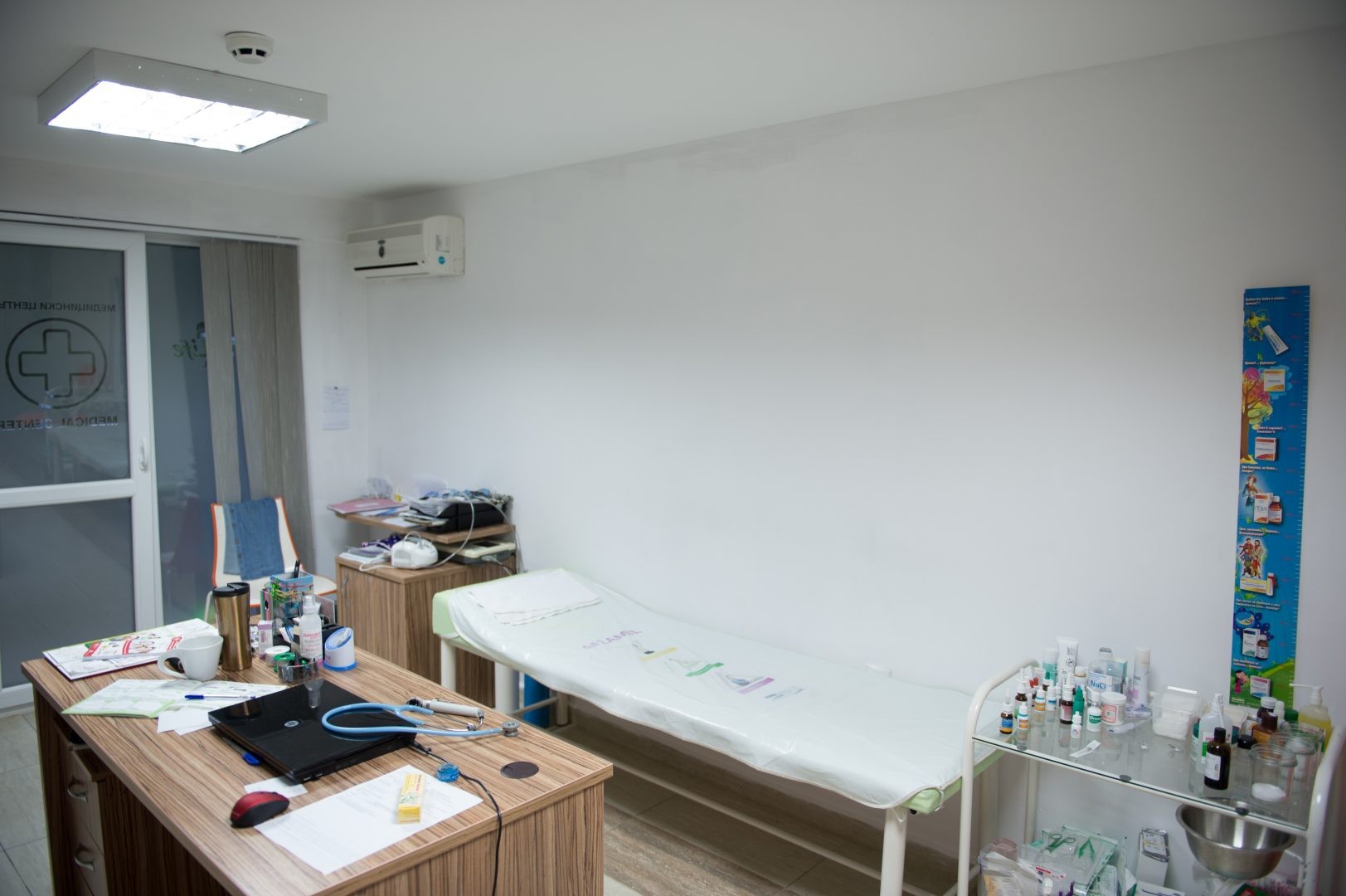 Medical treatment room with exam bed, desk, and supplies for athlete care during training camp