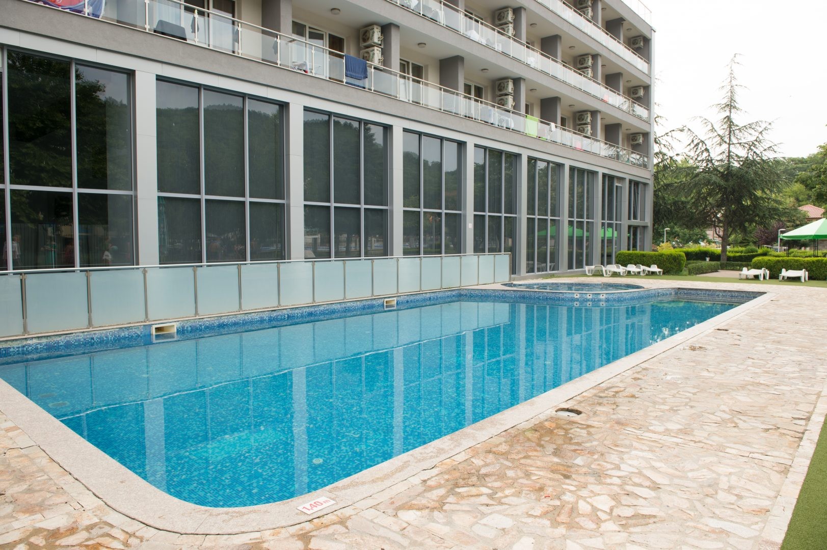 Rectangular outdoor pool next to hotel facade and terrace, suitable for training camp cooldowns