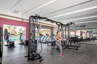 Athlete working out with strength machine in bright modern gym