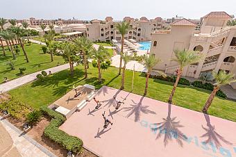 Aerial view of resort gardens with athletes training on outdoor court
