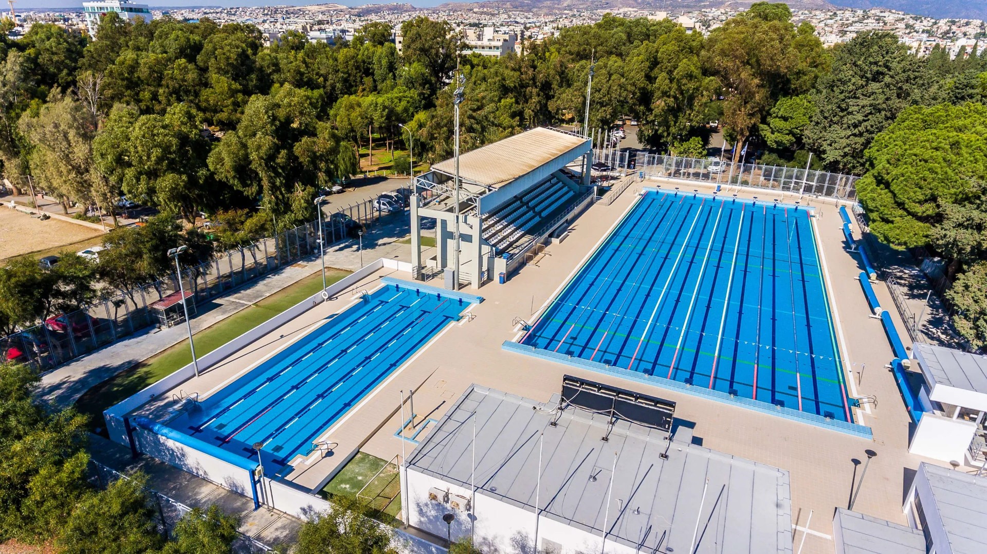 Erhöhte Ansicht eines Wettkampfschwimmkomplexes mit mehreren Bahnen und Sitzplätzen für Athletentraining