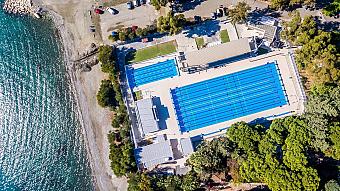 Draufsicht auf blaue Schwimmbecken neben dem Strand, ideal für Schwimmtrainingslager