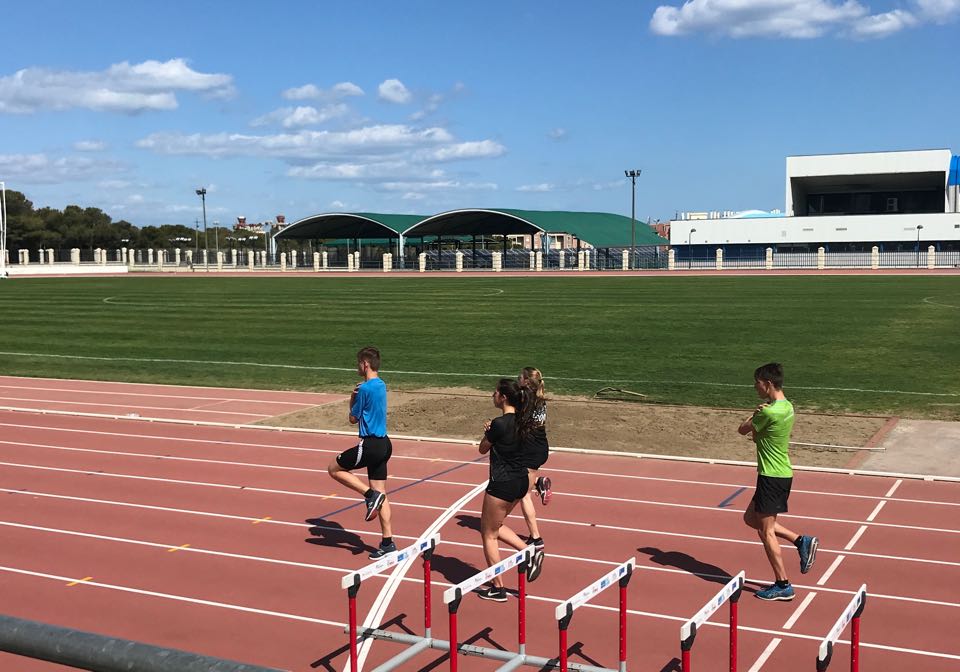 Athleten bei Hürden-Drills auf der Leichtathletikbahn.