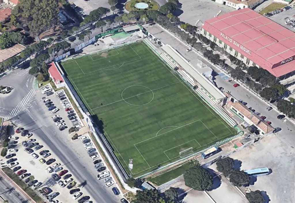 Luftaufnahme eines Fußballstadions mit Spielfeld, Tribünen und Sportgebäuden.
