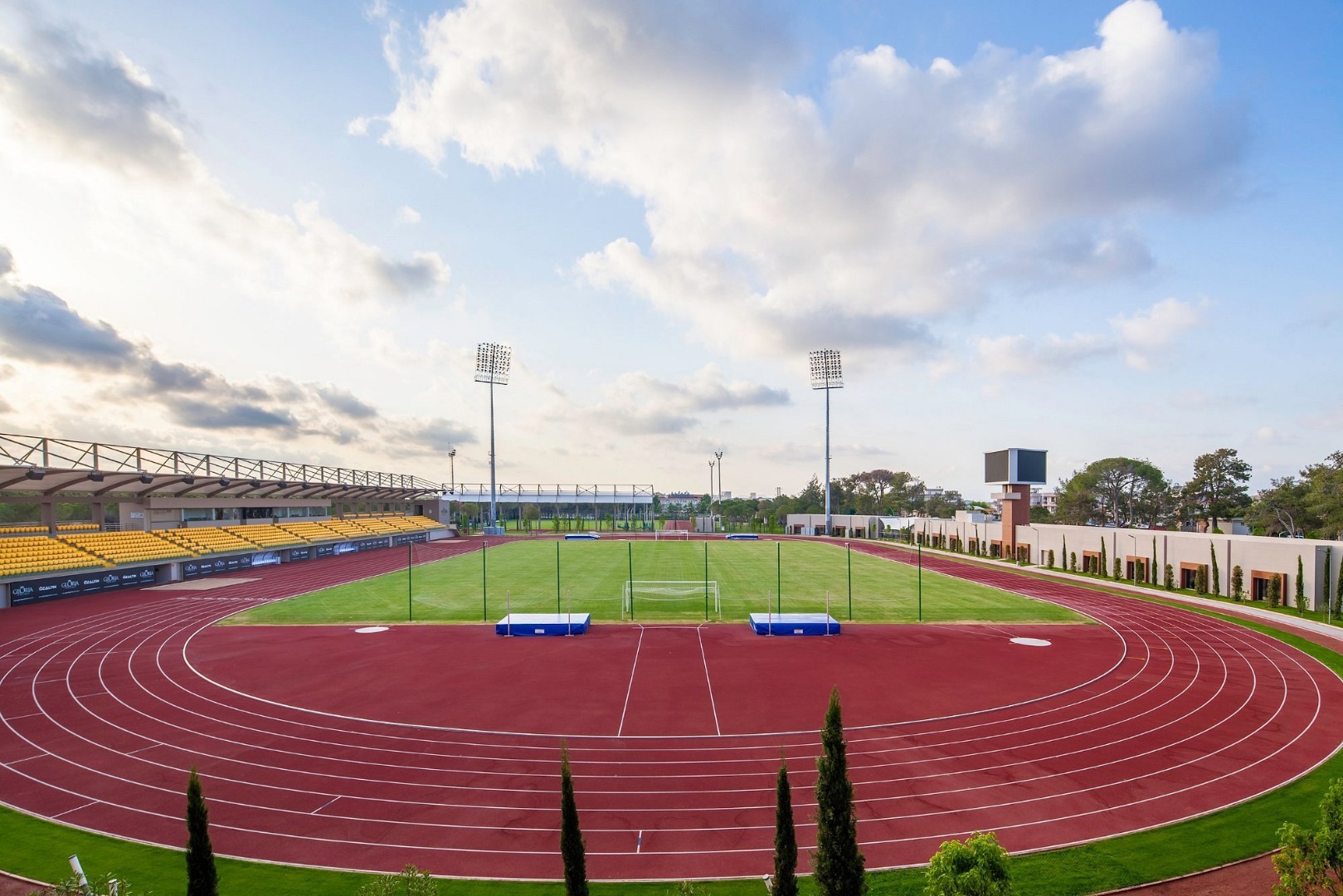 Leichtathletikstadion mit kompletter Laufbahn, zentralem Rasenfeld und Tribünen. Ideal für Bahneinheiten, Athletiktraining und vielseitige Trainingsformate.