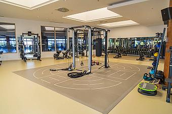 Spacious functional training studio with a multi-station rig, suspension trainers and a heavy bag, complemented by free weights and kettlebells. The open layout provides plenty of room for mobility work, stretching and circuit sessions.