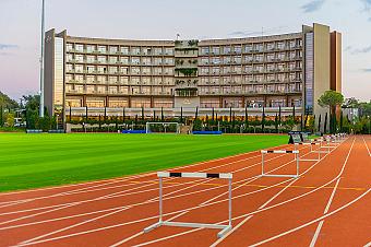 Leichtathletikbahn mit Innenfeld-Trainingsbereich und aufgebauten Hürden für Sprint- und Techniktraining. Flutlicht und viel Platz ermöglichen strukturierte Einheiten für Teams und Einzelsportler.