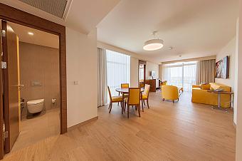 Barrier-free bathroom with a roll-in shower area, grab rails and an accessible washbasin. Designed for comfort and safety with ample space for easy movement.