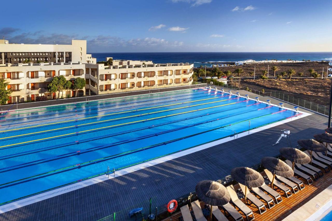 Piscine olympique extérieure avec couloirs marqués à côté du complexe et de la côte atlantique.