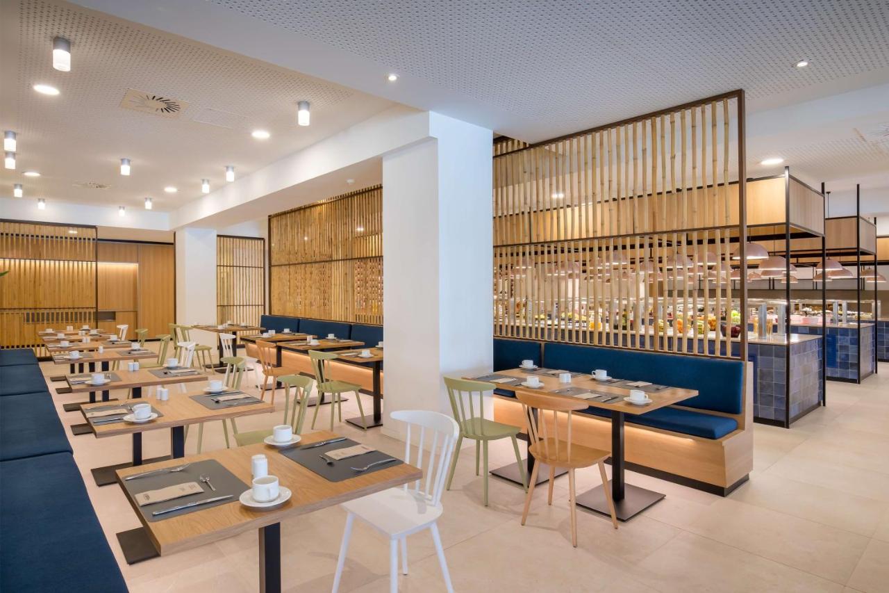 Restaurant buffet lumineux avec claustras en bois, banquettes et tables de restauration.