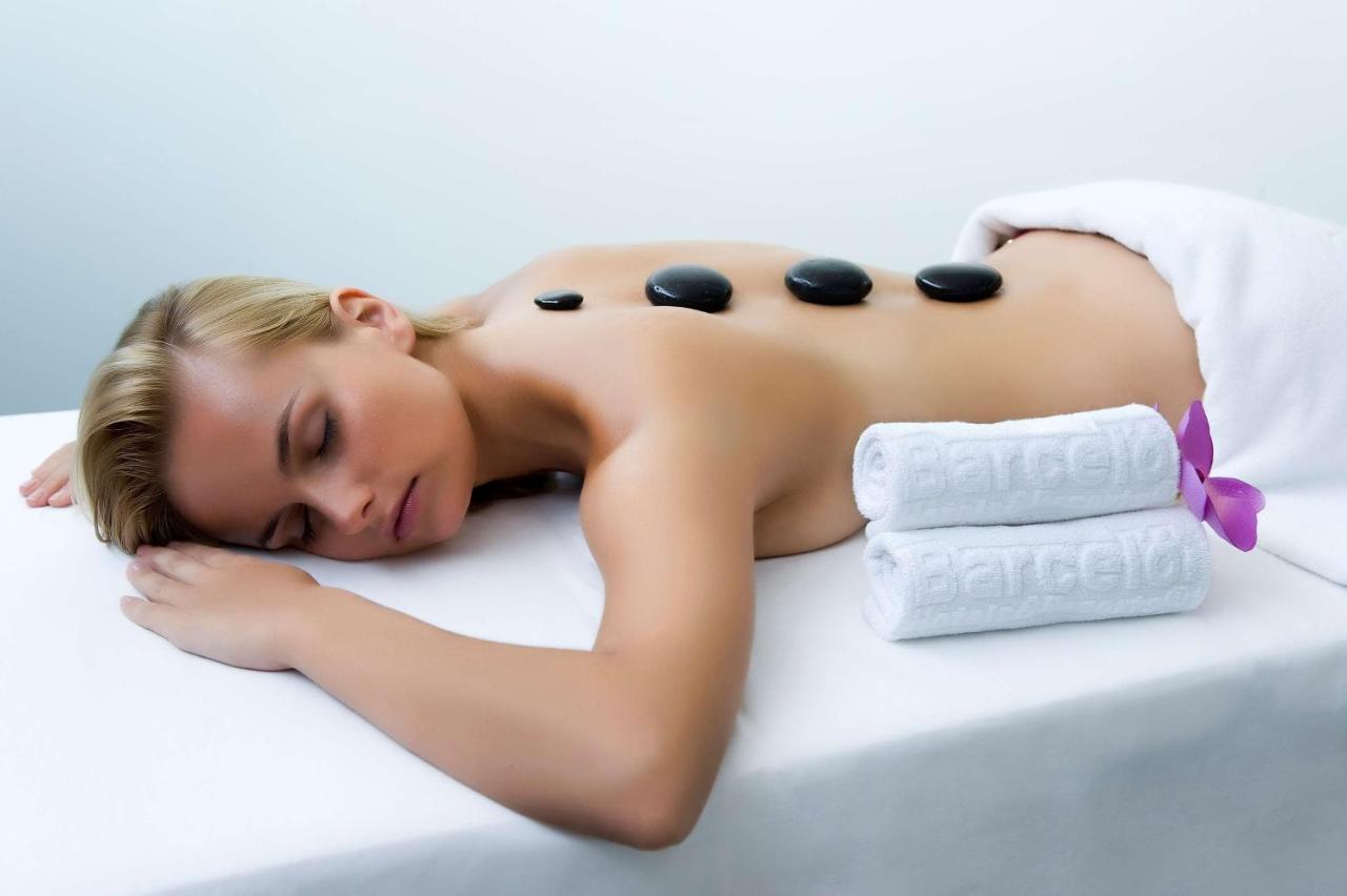 Personne recevant un massage aux pierres chaudes sur une table de soin.