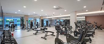 Spacious gym with free weights, strength machines and cardio equipment for workouts.