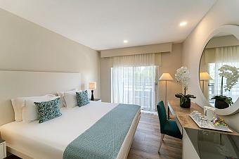 Double guest room with balcony doors, desk and dressing mirror.