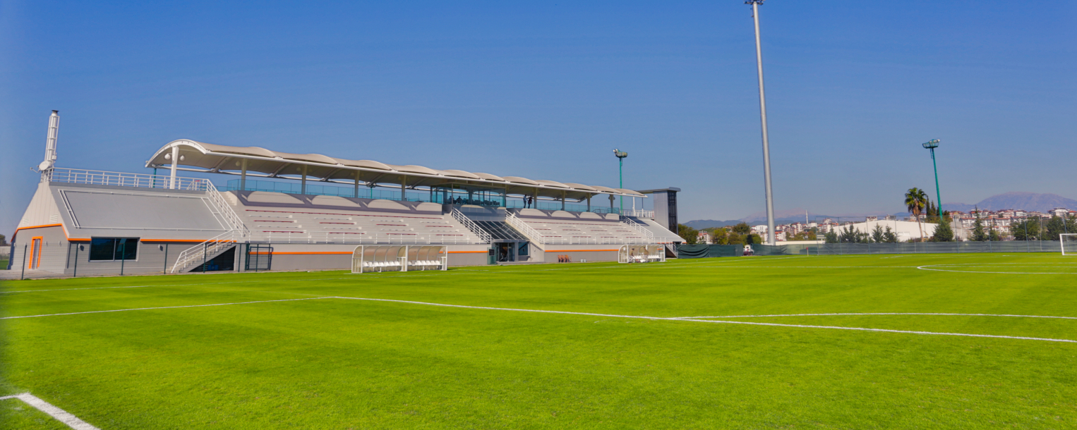 Tribüne am Fußballstadion neben einem Rasenplatz am Trainingslager-Standort.
