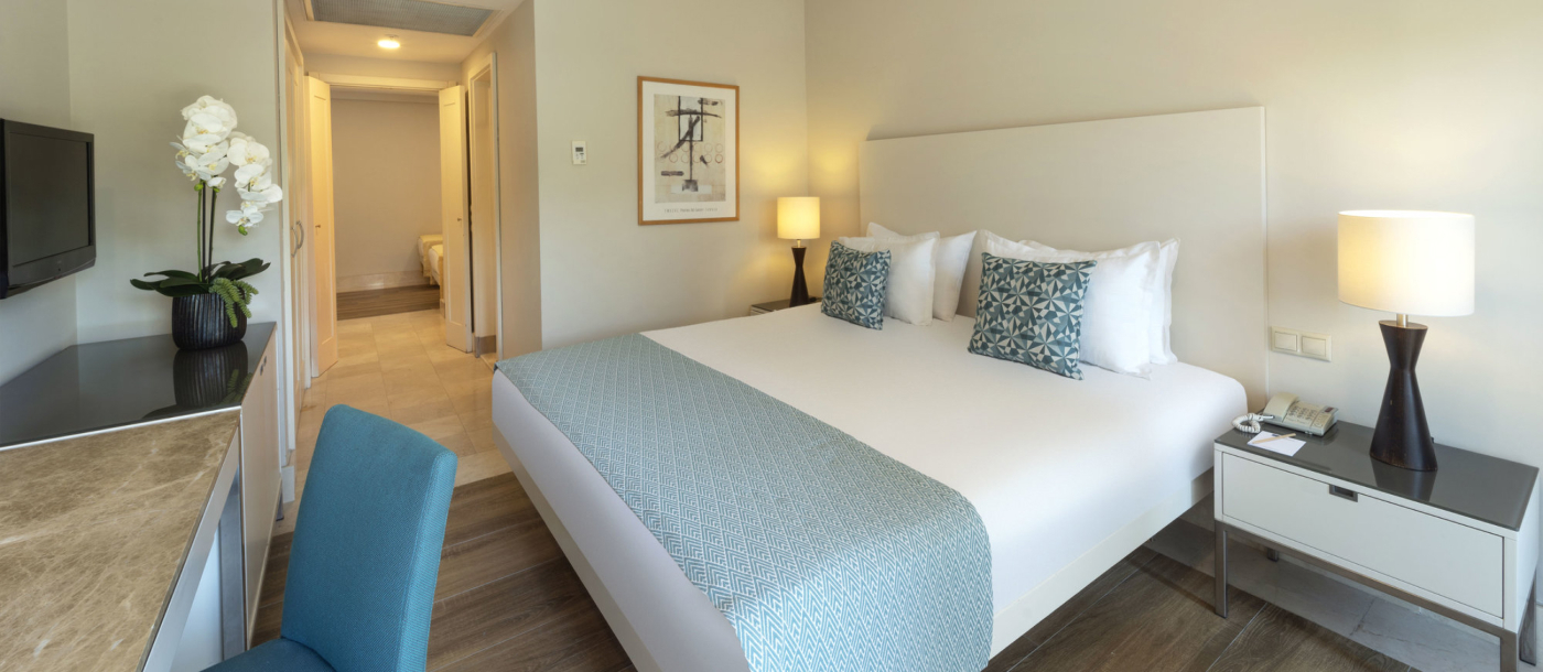 Gästezimmer mit Doppelbett, Schreibtisch und Flur zu einem weiteren Schlafbereich.