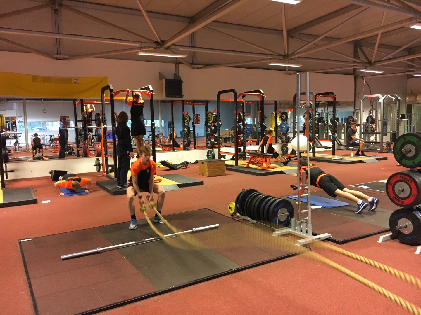 Athletes training with ropes and free weights