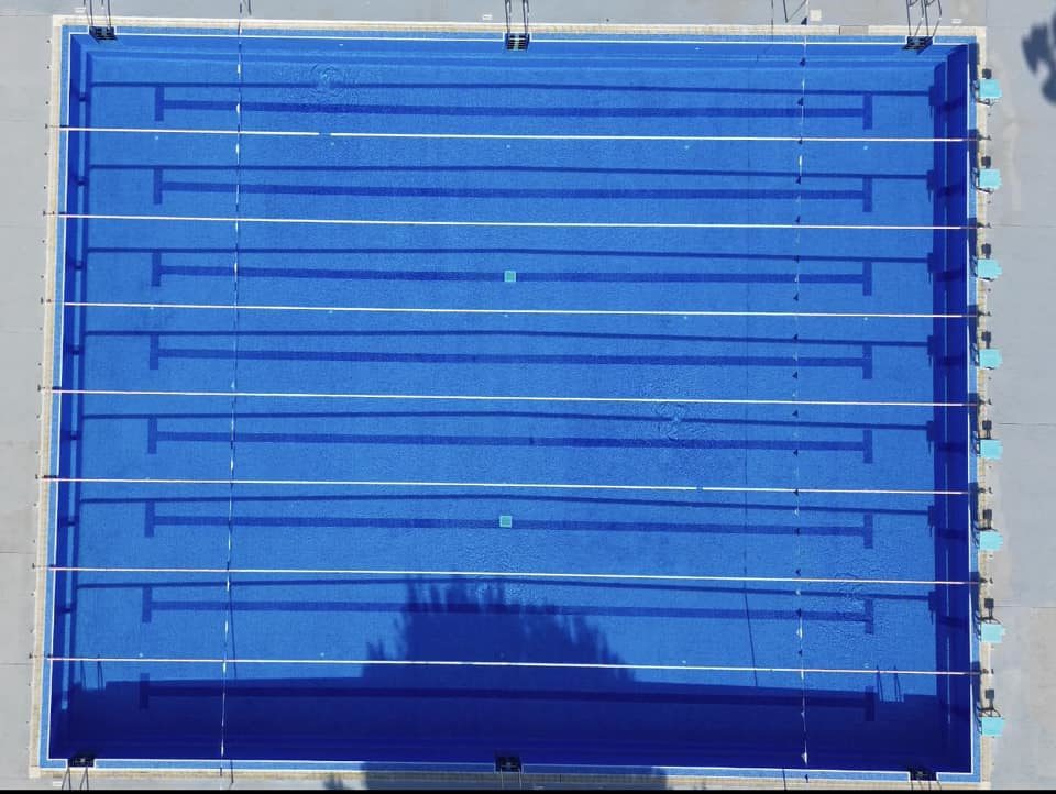 Draufsicht auf ein achtbahniges Außenbecken mit markierten Schwimmbahnen.