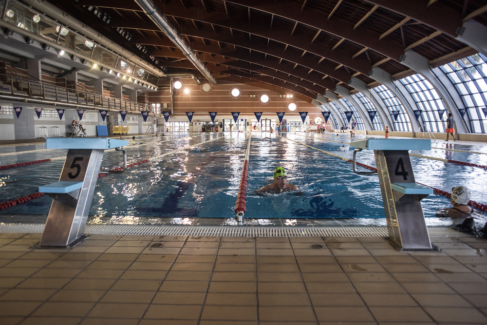 Indoor-Schwimmbecken mit Bahnleinen und Startblöcken während des Schwimmtrainings.
