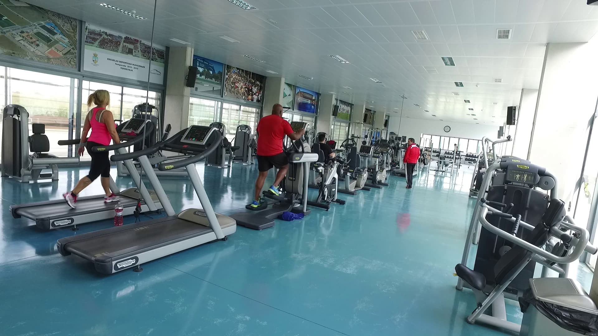 Gym-Bereich mit Laufbändern und Cardio-Geräten im Einsatz während eines Workouts.