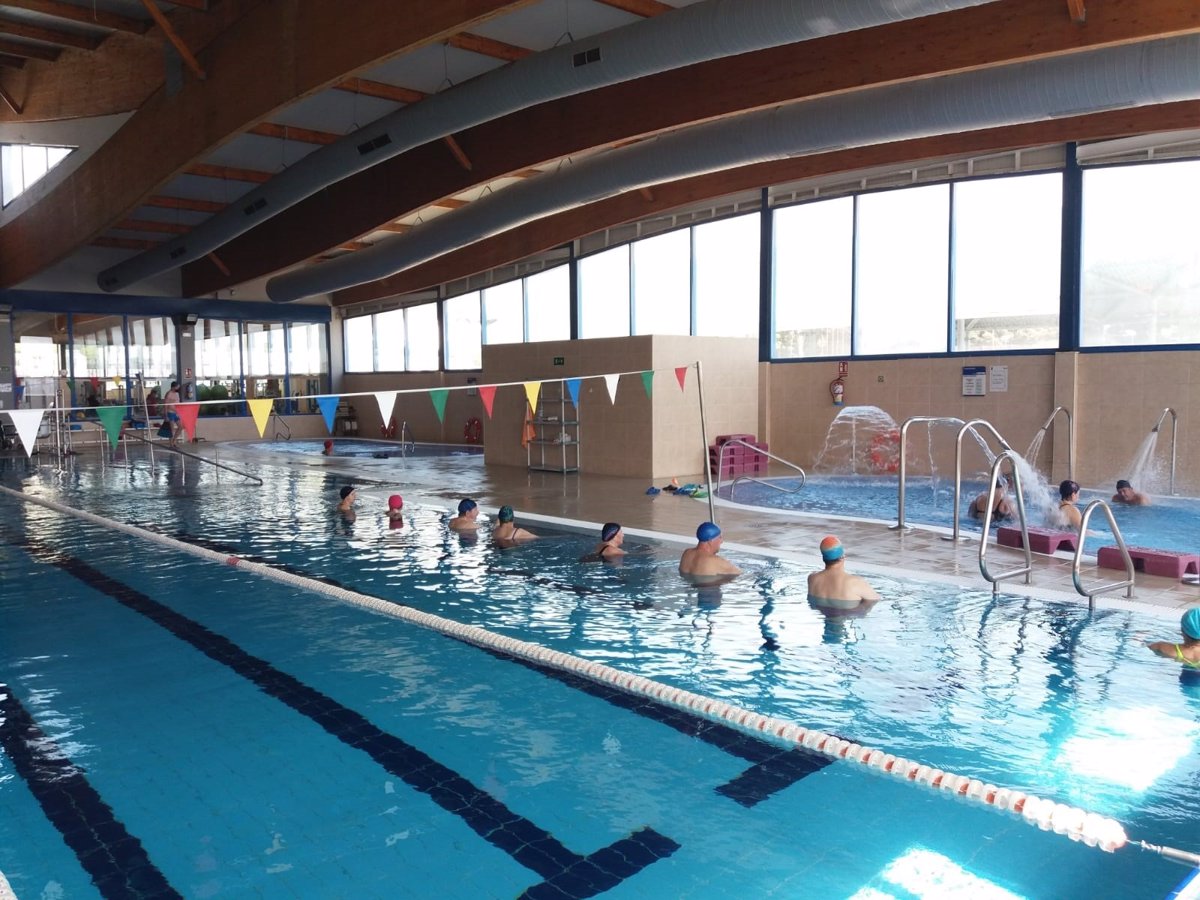 Innenpool mit Leine, Schwimmern im Wasser und einem flachen Bereich mit Wasserdüsen.