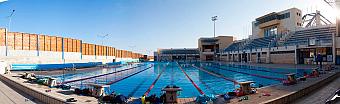 Panoramic view of the outdoor lane pool with starting blocks, training gear and grandstand seating.