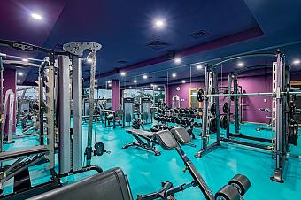 Gym with weightlifting equipment, benches, and dumbbells for athlete workouts