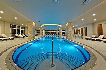 Indoor swimming pool with lounge chairs and modern lighting