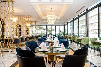 Elegant restaurant with modern decor, glass walls, and set dining tables