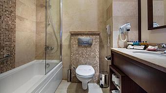 Bathroom with bathtub, shower, toilet, sink, and wall-mounted hairdryer