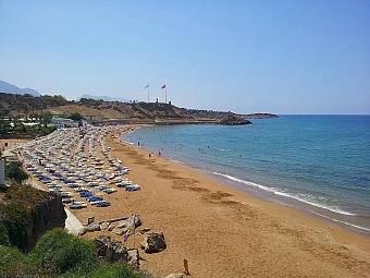 Wide sandy beach with umbrellas and sunbeds along the shoreline