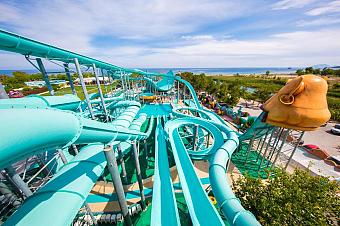 Waterpark area with large turquoise slides and pools near the coastline.