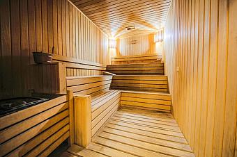 Wood-lined sauna cabin with tiered benches for recovery and relaxation.