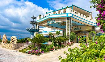 Haupteingang des Hotels mit dekorativem Brunnen, gepflegten Gärten und überdachtem Vorfahrtsbereich.