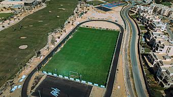 Luftaufnahme des Fußballtrainingsplatzes, umgeben von Straße und nahegelegenen Gebäuden