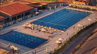 Großes Outdoor-Schwimmzentrum mit mehreren Becken und Sonnenschirmen