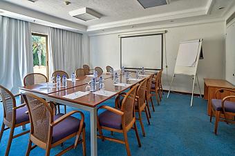 Besprechungsraum mit Tischen, Stühlen, Whiteboard und Projektor, vorbereitet für Coaching oder Team-Meetings