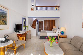 Helles Maisonette-Zimmer mit Sofa, Couchtisch, Bett und Balkon zur Entspannung der Athleten
