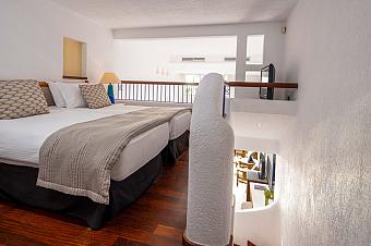 Hotelzimmer im Loft-Stil mit zwei Einzelbetten auf einer oberen Ebene und Treppe darunter