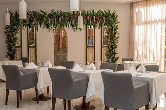 Eleganter Speisesaal mit weißen Tischdecken, grauen Stühlen und Blumendekoration für Teammahlzeiten