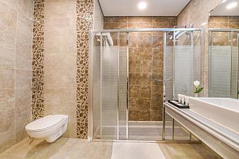 Modern bathroom with walk-in shower, glass doors, and tiled walls