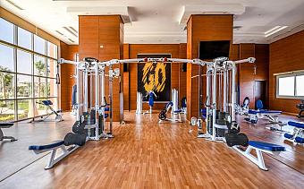 Hotel gym with weight machines and workout equipment on wooden flooring