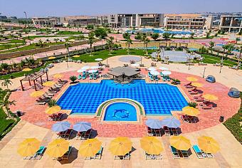 Outdoor pool with dolphin mosaic, surrounded by sun loungers and umbrellas