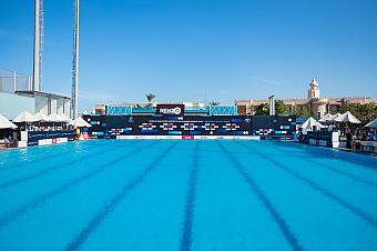 Outdoor Olympic swimming pool with diving platforms and banners for competition or training camp
