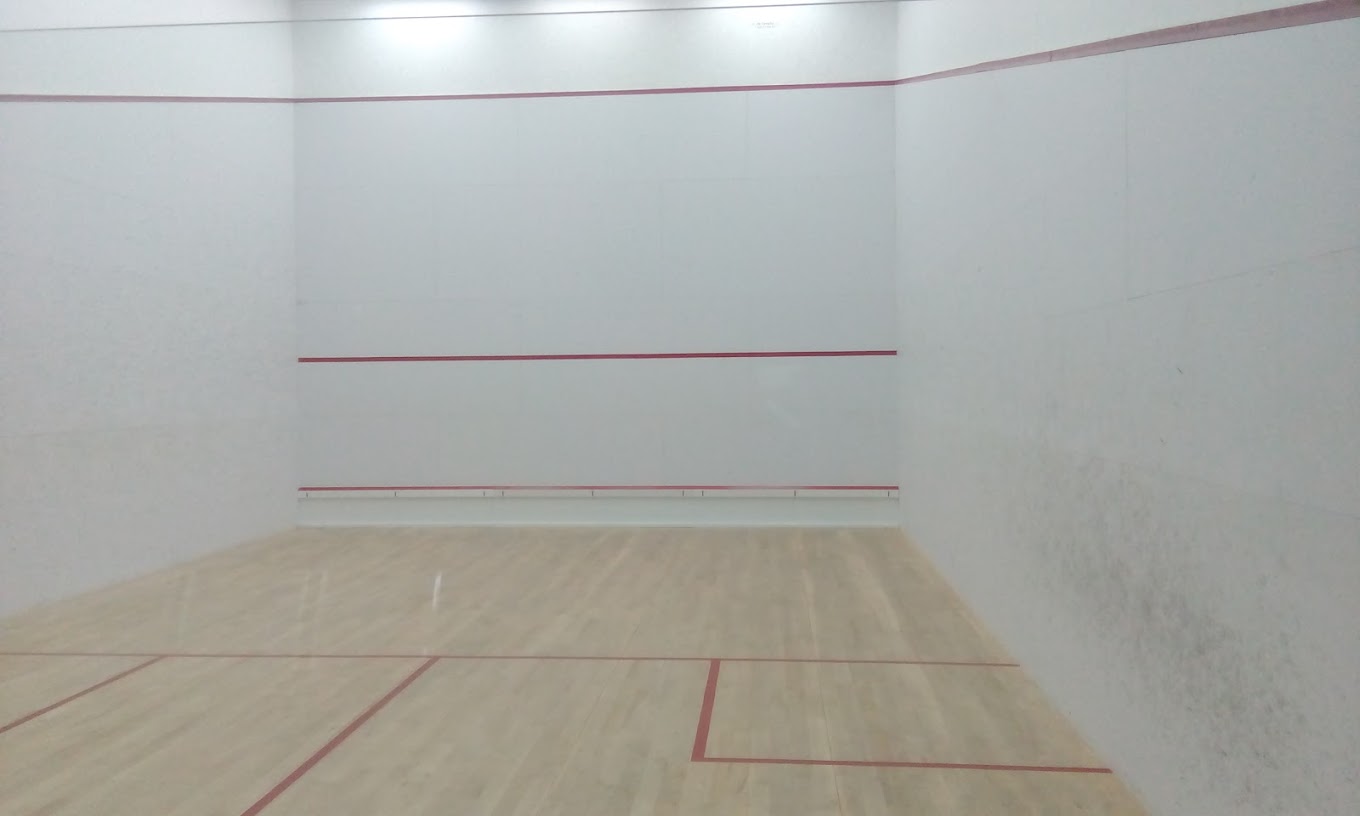 Leerer Indoor-Squashcourt mit Holzboden und roten Linien, bereit für Trainingsdrills.